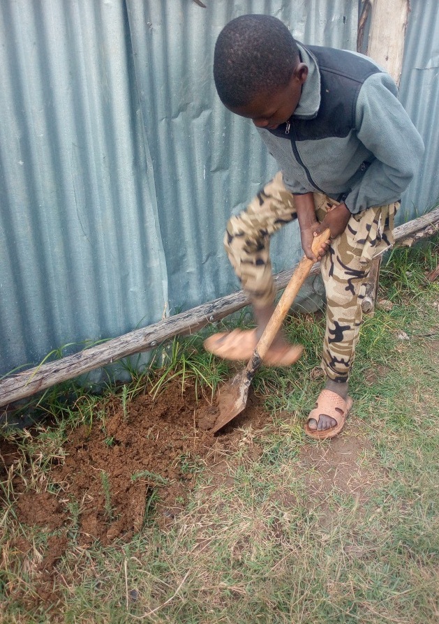 Kinoti (YOU.REP Kid) making a whole for planting the tree